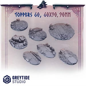 May include: Set of 6 oval-shaped, grey resin, 60x90mm, miniature bases with a ruined stone and cobblestone design.  The bases are designed for use with tabletop games and miniatures.  TOPPERS 60, 60X90, 90MM is printed on the image.