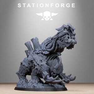 May include: A gray, detailed figurine of a fantasy creature with a horned head, large tusks, and a textured, armored body. The figurine is on a black base, with the word "STATIONFORGE" and a skull logo above it.
