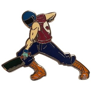 May include: An enamel pin featuring a cartoon character wearing a helmet and holding a large knife. The character is wearing blue jeans and orange boots.