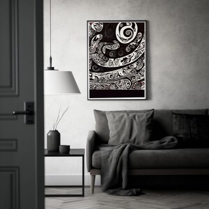 May include: A black and white framed print of an abstract design with swirling patterns. The print is hanging on a gray wall above a gray couch with a throw blanket.