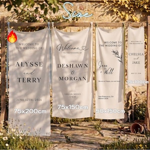 May include: Four white wedding banners with black text, displayed on a wooden frame. The banners vary in size, with the largest measuring 75x200cm. Each banner welcomes guests to a wedding, with names and dates. The banners are set outdoors.