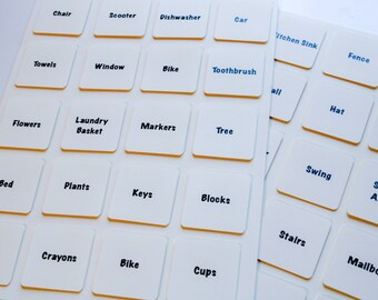 May include: White labels with black text on a white background. The labels are arranged in a grid and include words like "Scooter", "Dishwasher", "Car", "Chair", "Toothbrush", "Bike", "Towels", "Window", "Flowers", "Laundry Basket", "Markers", "Tree", "Bed", "Plants", "Keys", "Blocks", "Shoes", "Crayons", "Bike", "Cups", "Kitchen Sink", "Fence", "Hat", "Refrigerator", "Swing", "Stuffed Animal", "Stairs", "Mailbox".