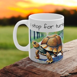 May include: White ceramic coffee mug with a brown and yellow turtle illustration and the text "I stop for turtles".