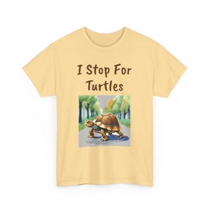 May include: A yellow t-shirt with the text "I Stop For Turtles" printed on the front. The shirt features a graphic of a turtle walking across a road.