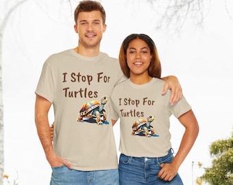 May include: Two people wearing beige t-shirts with a brown turtle graphic and the text "I Stop For Turtles".