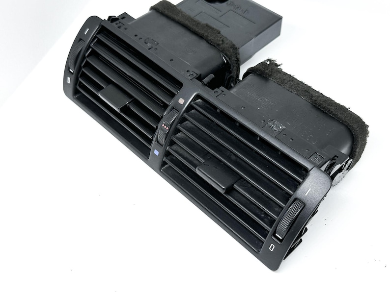 Peut inclure: A&eacute;rateur d'air de voiture en plastique noir avec deux boutons r&eacute;glables et une grille rectangulaire.