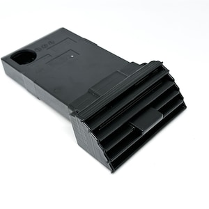 Peut inclure: A&eacute;rateur d'air de voiture en plastique noir de forme rectangulaire avec une s&eacute;rie de lamelles horizontales. L'a&eacute;rateur a une petite ouverture rectangulaire sur le dessus.