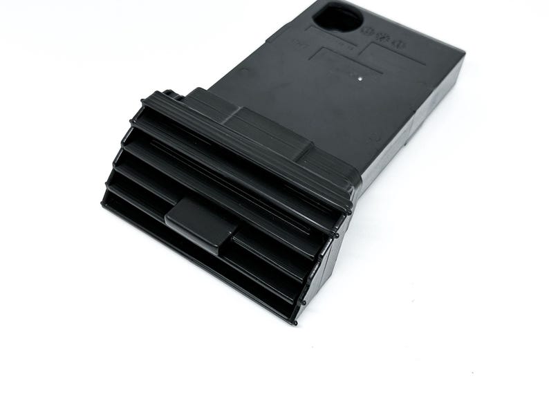 Peut inclure: A&eacute;ration de voiture en plastique noir de forme rectangulaire avec une s&eacute;rie de lamelles horizontales. L'a&eacute;ration a une petite ouverture rectangulaire sur le dessus.