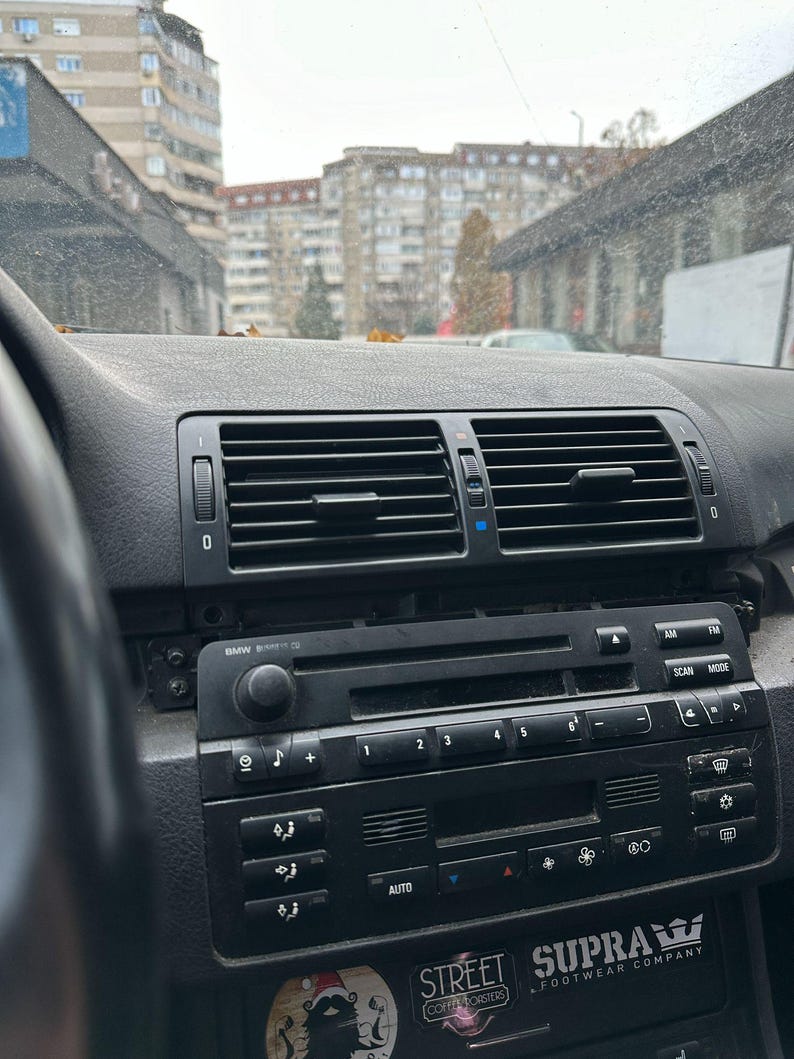 Peut inclure: Un tableau de bord de voiture noir avec une radio, des commandes de climatisation et un autocollant qui dit "STREET COFFEE ROASTERS" et "SUPRA FOOTWEAR COMPANY".