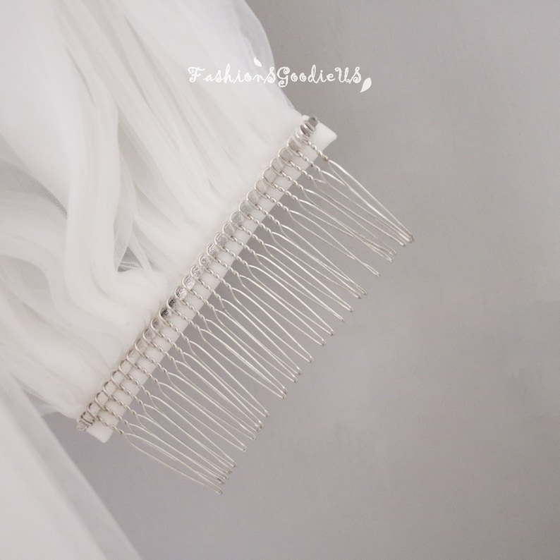 May include: A white tulle veil with a silver comb. The comb has a row of small rhinestones.