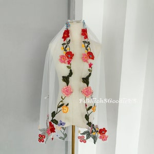 May include: White bridal veil with colourful floral embroidery. The embroidery features red, pink, yellow, blue and green flowers.