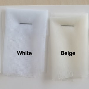 May include: Four swatches of tulle fabric in different colors: ivory, white, beige, and champagne. Each swatch is labeled with its color name.