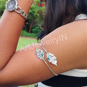 Op de afbeelding: Zilveren armbandsluiting met twee blaadjes, elk met een turquoise steen. De sluiting is open en verstelbaar.