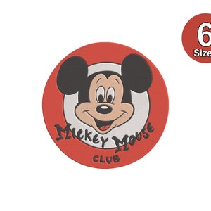 以下が含まれることがあります： 中央に白い円がある赤い丸いコースター。円にはミッキーマウスの顔の漫画の画像が描かれています。白い円の周りに黒い文字で「Mickey Mouse Club」と書かれています。