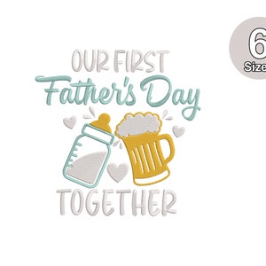 Pode incluir: Design de bordado "Nosso primeiro Dia dos Pais juntos" com uma mamadeira e um copo de cerveja. O design é em azul, branco e amarelo.