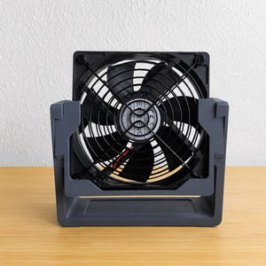 May include: A square black electric cooling fan with seven blades, encased in a protective wire grille. The fan is mounted within a dark gray plastic U-shaped stand that allows for rotation. The center of the fan features a circular label with the text ELTENG.