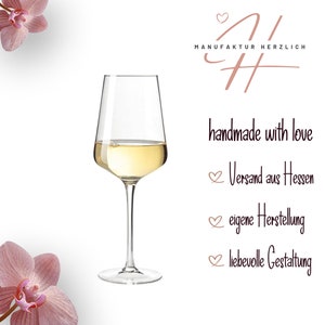 May include: A clear glass wine glass filled with white wine, positioned between two pink orchid flowers. The text MANUFAKTUR HERZLICH, handmade with love, Versand aus Hessen, eigene Herstellung, and liebevolle Gestaltung appears on the right side.