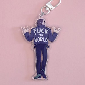 Könnte beinhalten: Ein blauer und weißer Acryl-Schlüsselanhänger mit einer Comicfigur, die eine Jacke mit dem Text "FUCK THE WORLD" auf dem Rücken trägt. Der Schlüsselanhänger hat einen silbernen Metallring.