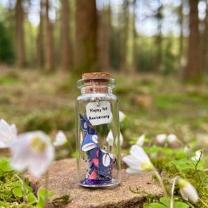 Dije de conejo de origami japonés para el primer aniversario con mensaje personalizado en una botella. Incluye una nota de regalo.