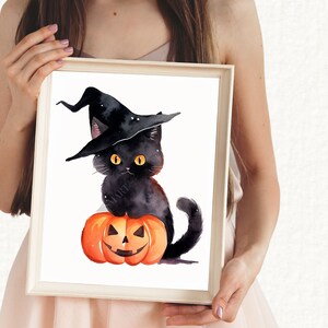 May include: A black cat wearing a witch's hat sits on top of an orange pumpkin with a jack-o'-lantern face. The cat has yellow eyes and a black nose. The background is white.