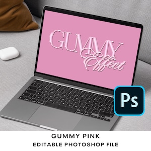 May include: A laptop screen displaying a pink background with the text "GUMMY Effect" in a pink, 3D, glossy font. The laptop is open and the keyboard is visible. The Photoshop logo is in the bottom right corner of the screen. The text "GUMMY PINK EDITABLE PHOTOSHOP FILE" is displayed below the laptop.