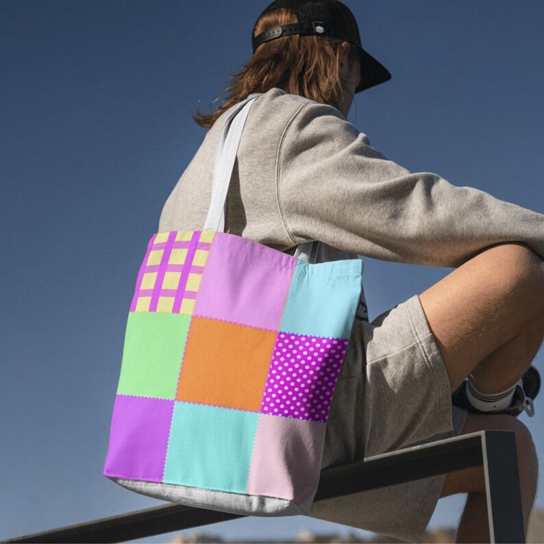 以下が含まれることがあります： 紫、オレンジ、緑、青など、さまざまな模様と色を使ったカラフルなパッチワークトートバッグ。白いストラップが付いており、生地でできています。デザインは、水玉模様や格子柄など、さまざまな模様の正方形が特徴です。