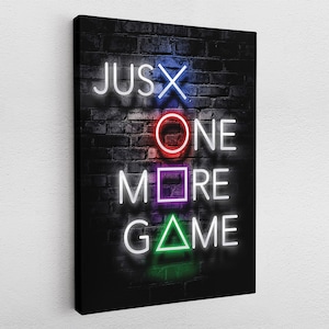 Könnte beinhalten: Neon-Schild an einer Backsteinwand mit der Aufschrift "Just One More Game", wobei die Wörter so gestaltet sind, dass sie wie die PlayStation-Controller-Tasten aussehen.