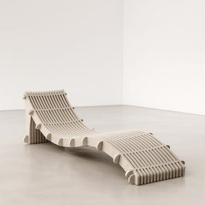 Può includere: Una chaise longue beige chiaro dal design a doghe. Lo schienale e la seduta curvi sono sostenuti da doghe verticali, creando un'estetica contemporanea. La chaise longue è realizzata in un materiale di colore chiaro. Misura circa 180 cm di lunghezza.
