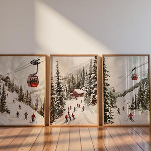 May include: A triptych of framed watercolor prints depicting snowy mountain landscapes with skiers and red cable cars. The artwork features evergreen trees, snow-covered slopes, and small wooden cabins, all rendered in a winter color palette.
