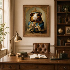May include: A framed wall art print featuring a portrait of a guinea pig dressed in a blue royal coat with gold trim and a matching crown. The guinea pig has brown, black, and white fur and is depicted in a regal pose against a neutral background.