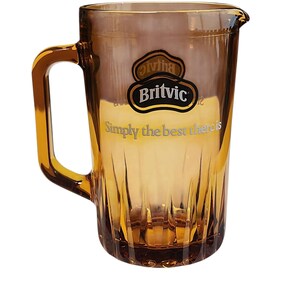 Può includere: Una caraffa in vetro color ambra traslucido dotata di un manico robusto e di una base scanalata. La parte anteriore presenta il logo Britvic nero e oro con la scritta "Simply the best there is" stampata in bianco sotto il marchio.