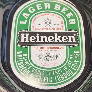 Puede incluir: Una bandeja ovalada negra y verde de cerveza Heineken con el texto LAGER BEER, Heineken, DIPLOME D'HONNEUR AMSTERDAM 1883, HORS CONCOURS MEMBRE DU JURY PARIS 1900, GRAND PRIX PARIS 1889, MEDAILLE D OR PARIS 1875 y WHITBREAD & CO PLC LONDON EC1Y 4SD.