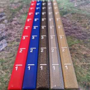 May include: Six rulers, each with a different color: red, blue, black, gray, silver, and gold. The rulers are marked with numbers from 1 to 5.