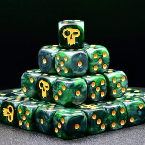 May include: A pyramid of green and black dice with yellow pips and skull symbols. The dice are arranged in a pyramid shape, with the top die featuring a skull symbol. The dice are for tabletop games.