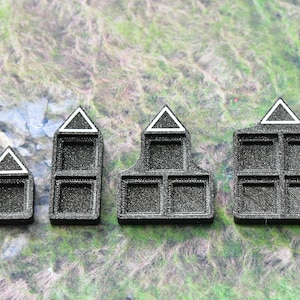 May include: Four black and white plastic storage containers with triangular tops and square compartments. The containers are arranged in a row from smallest to largest.