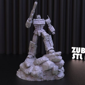 May include: A gray 3D printed model of Optimus Prime, a robot from the Transformers franchise, standing on a rocky base. The model is holding a gun in its right hand. The background is a black curtain. The text "ZUBARH STL ART" is visible in the lower right corner of the image.