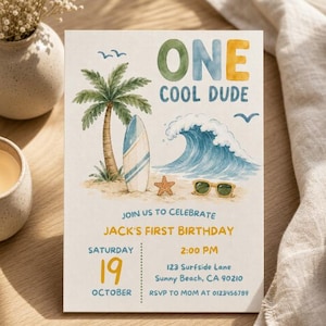 Op de afbeelding: Een rechthoekige verjaardagsuitnodigingskaart met aquarelillustraties van een palmboom, een surfplank, een blauwe oceaangolf, een zeester en een zonnebril. De tekst luidt ONE COOL DUDE, JOIN US TO CELEBRATE JACK'S FIRST BIRTHDAY, SATURDAY 19 OCTOBER, 2:00 PM, 123 Surfside Lane, Sunny Beach, CA 90210, RSVP TO MOM AT 0123456789.
