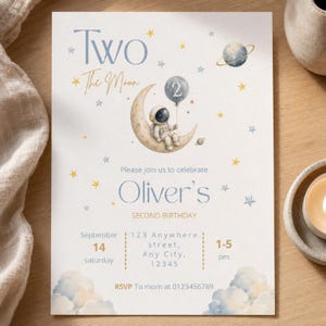 Op de afbeelding: Een rechthoekige verjaardagsuitnodiging met een aquarel astronaut zittend op een maansikkel, vasthoudend aan een ballon met het cijfer 2. De tekst luidt Two The Moon, Oliver's SECOND BIRTHDAY, 14 september en de evenementgegevens.