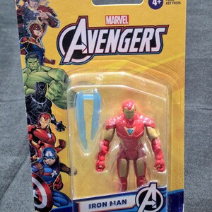 Puede incluir: Una figura de acci&oacute;n de Iron Man de Marvel Avengers en su empaque bl&iacute;ster amarillo original. La tarjeta presenta ilustraciones de Thor, Captain Marvel, Hulk, Black Panther, Iron Man y Captain America. La figura es roja y dorada con un accesorio azul.