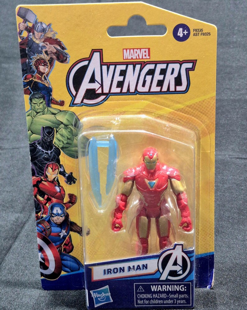 Puede incluir: Una figura de acci&oacute;n de Iron Man de Marvel Avengers en su empaque bl&iacute;ster amarillo original. La tarjeta presenta ilustraciones de Thor, Captain Marvel, Hulk, Black Panther, Iron Man y Captain America. La figura es roja y dorada con un accesorio azul.