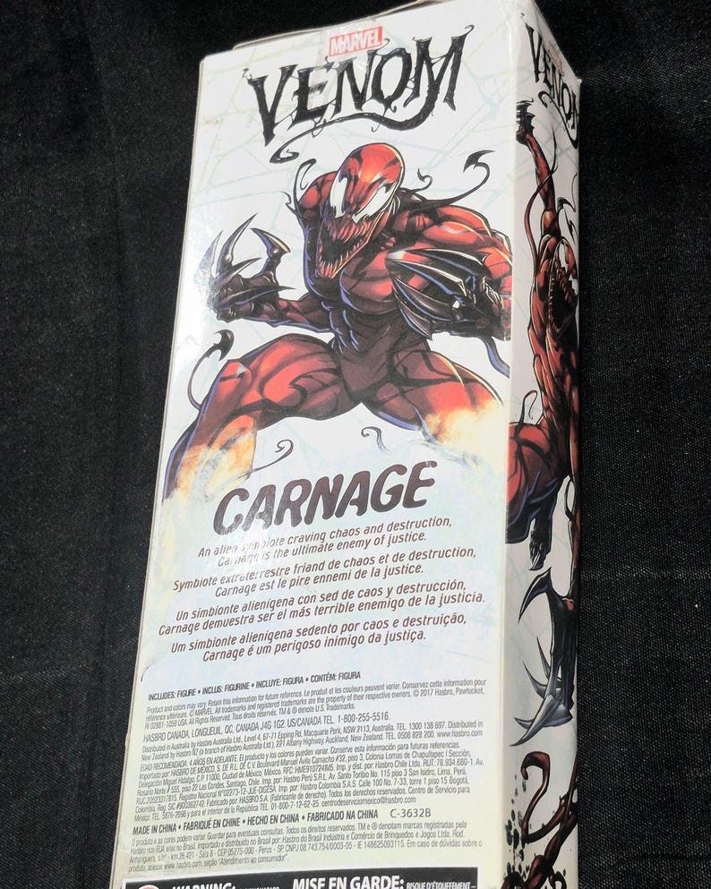 May include: A rectangular white cardboard packaging box for a Marvel Venom Carnage action figure. The front features a large, detailed illustration of the red and black Carnage character with sharp claws, the Venom logo, and descriptive text.