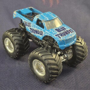 Pair of Hot Wheels Monster Jam Trucks including Blue Thunder & Instigator in good preowned condition.
