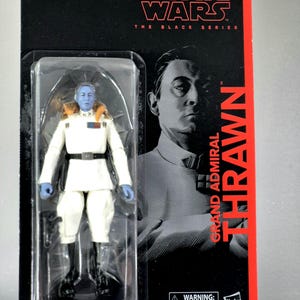 May include: A Star Wars The Black Series action figure of Grand Admiral Thrawn. The figure is in a clear plastic package with a black and red backing. Thrawn is depicted in a white uniform with blue skin and black boots.