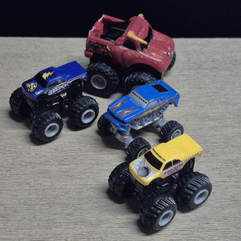 Hot Wheels Mini Monster Truck & Monster Jam Lot.  Includes Hot Wheels Monster Jam Shocker, Yellow body Wrecking Crew, Ford Mustang with flame graphics & Monster Jam El Toro Loco vehicle with pull back friction motor. El Toro is missing a horn, otherwise Lot is in Good Preowned Condition.