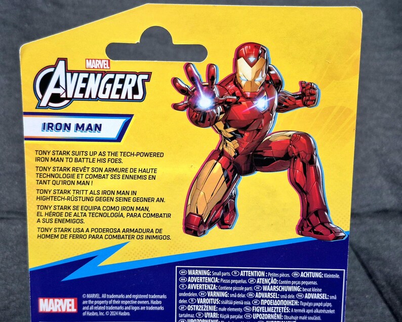 Puede incluir: Una tarjeta de respaldo para figura de acci&oacute;n Marvel Avengers amarilla con Iron Man en un traje rojo y dorado. La tarjeta muestra el logo de Avengers, el texto Iron Man, texto descriptivo en varios idiomas y una etiqueta de advertencia.