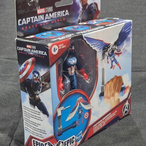 May include: A Marvel Studios Captain America Brave New World Epic Hero Series action figure in its original packaging. The box features graphics of the character with wings, a shield, and flight control accessories, with a 4+ age rating visible.