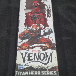 May include: A Carnage action figure from the Marvel Venom Titan Hero Series in its original packaging. The box features a red and black character illustration, the text Carnage, Marvel Venom, and Titan Hero Series, with an age rating of 4+.