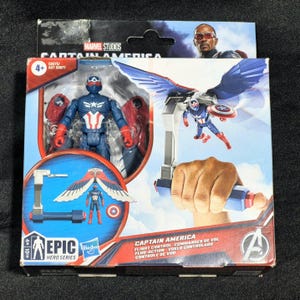 May include: A Marvel Studios Captain America Epic Hero Series action figure in packaging. The blue and red figure features a star emblem and detachable wings. The box displays the character, flight control accessories, and the Avengers logo.