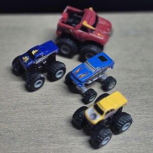 Hot Wheels Mini Monster Truck & Monster Jam Lot.  Includes Hot Wheels Monster Jam Shocker, Yellow body Wrecking Crew, Ford Mustang with flame graphics & Monster Jam El Toro Loco vehicle with pull back friction motor. El Toro is missing a horn, otherwise Lot is in Good Preowned Condition.