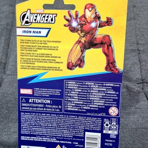 Puede incluir: Una tarjeta de embalaje de figura de acci&oacute;n de Marvel Avengers Iron Man con un fondo amarillo y azul y un gr&aacute;fico de Iron Man en cuclillas. La tarjeta incluye el logotipo de Marvel Avengers, texto del producto, advertencias y un c&oacute;digo de barras.